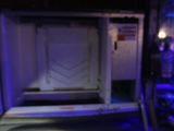a white door in the middle of a room with a blue light