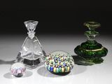 trois objets en verre de couleurs différentes posés sur une table