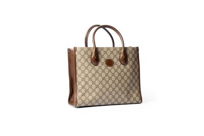 un sac à main beige et marron posé sur une surface blanche