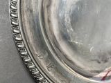 a silver plate with a candy cane in it on a table