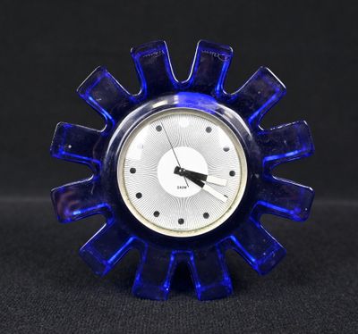 une horloge bleue posée sur une table noire