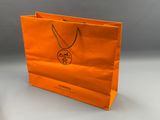 un sac de courses orange orné d'un logo, posé sur une table