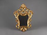 un cadre doré richement décoré surmonté d'un miroir