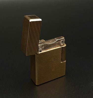un briquet doré posé sur une surface noire