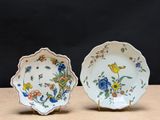 deux assiettes ornées de fleurs et d'oiseaux, posées sur une table