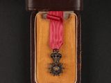 medal in a case with a red ribbon on a black background