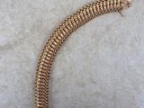 a close up of a gold chain bracelet on a concrete surface