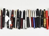 a lot of pens that are lined up on the table