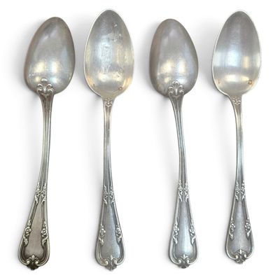 four spoons are lined up in a row on a white surface