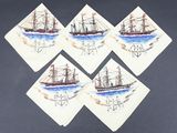 quatre serviettes de table ornées de dessins de bateaux, posées sur une table