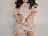 a doll that is sitting on a white surface