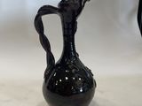 a black vase that is sitting on a table