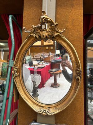 Miroir de forme ovale en bois et stuc doré à décor de rinceaux et acan - Photo 1