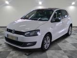 la voiture blanche est garée sur un sol en damier dans le garage