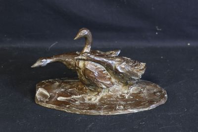a bronze statue of a duck on a rock