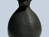 a black vase with a man ' s face on it