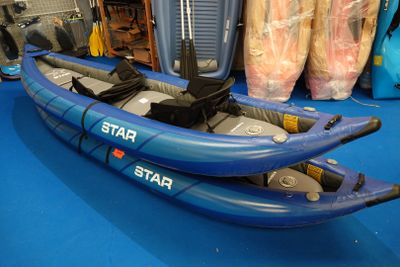 un kayak bleu posé sur un sol bleu dans une pièce