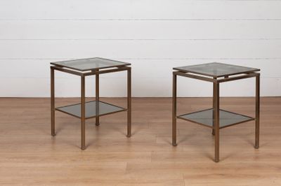 une paire de tables d'appoint en verre et en laiton posées sur un parquet