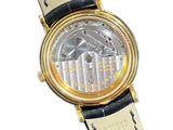 a gold watch with a black strap on a white background
