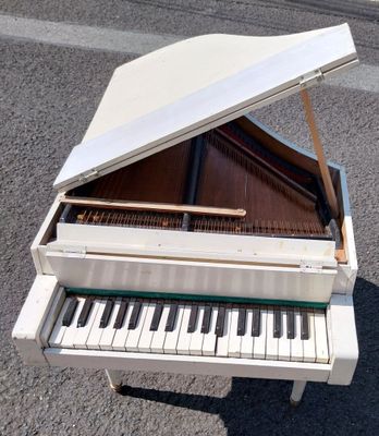 un piano blanc posé au milieu de la rue