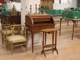 de nombreuses chaises et tables dans une pièce où il y a beaucoup de cartons par terre