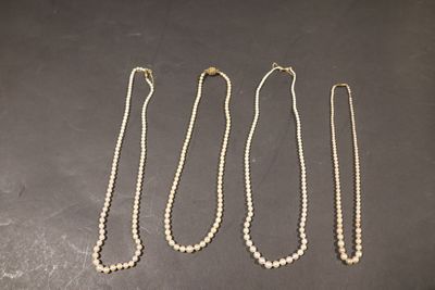 trois colliers ornés de perles posés sur une table