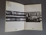 an open book with a picture of a city in it