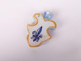 a blue and white pin with a blue flower on it