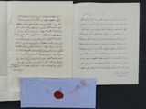 an open book with a piece of paper and a red wax stamp on it
