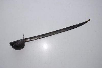 a small sword that is laying on a white surface