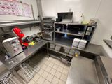 une cuisine avec beaucoup de plan de travail et une cafetière rouge
