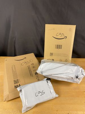 two bags of white paper sitting on top of a table next to a cardboard box