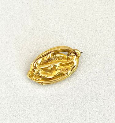 an image of a gold plated brooch depicting a woman ' s face