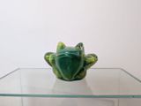 a glass table with a frog figurine on top of it