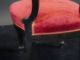 a red chair that is sitting on a black floor