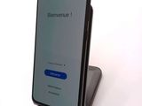 the back view of a smartphone with a blue button on the screen