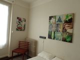 a white bed in a room with paintings on the wall