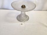 a glass cake plate on a table with a white tablecloth
