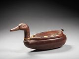 an old wooden duck shaped object sitting on top of a table