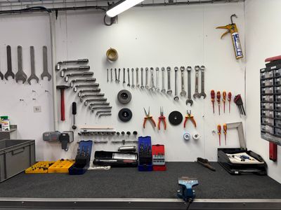 Il y a de nombreux outils accrochés au mur dans ce garage.