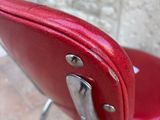 a red chair with a metal frame and a red seat
