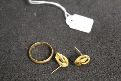 deux bagues en or et une paire de boucles d'oreilles posées sur une table