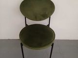 a green chair sitting in front of a white wall