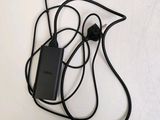 a cell phone connected to a charger on a white surface