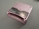 a pink electronic device sitting on a table next to a mouse