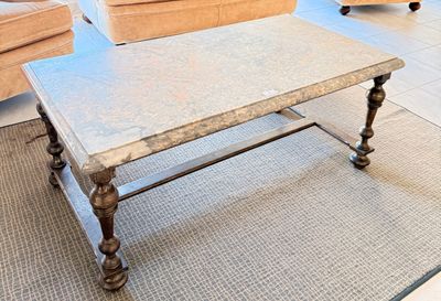 une table basse avec un plateau en marbre dans un salon
