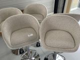 trois chaises alignées, équipées de roulettes, dans une pièce dotée d'une fenêtre