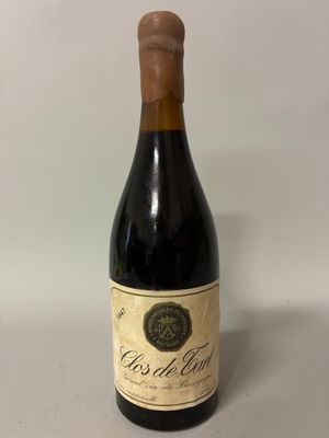 an old bottle of wine sitting on top of a table
