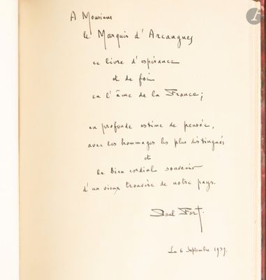 un livre ouvert, sur lequel est inscrit un poème manuscrit, posé sur une table