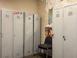 several lockers in a room with a chair in front of them